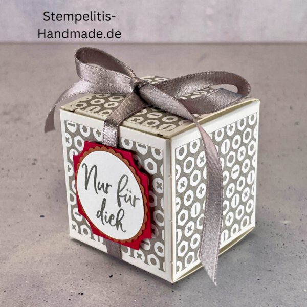 handdekorierte Geschenkschachtel mit Aufschrift „Nur für dich“, Geschenkschachtel mit grauem Muster und rotem Etikett, kleine Geschenkbox mit Satinband, Vorderansicht der Schachtel „Nur für dich“, offene Geschenkbox mit Inhalt, Detailaufnahme Schriftzug „Nur für dich“, stilvolle Geschenkverpackung mit Band
